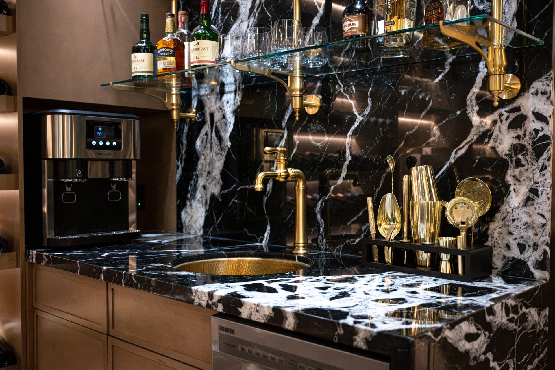 Bar detail with black marble, hammered gold sink, brass tapware, and gold bar tools