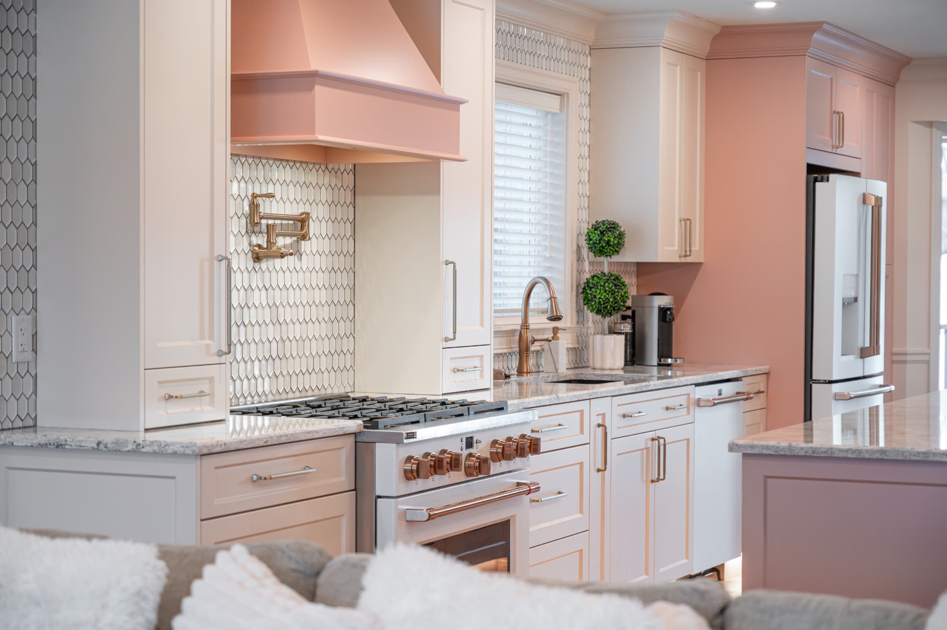Kitchen viewed from the lounge with a copper range hood, hexagon backsplash, and brass hardware